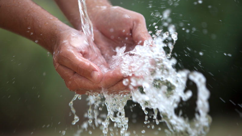 Two Cupped Hands Feel The Water Spashing Into Them Gently.